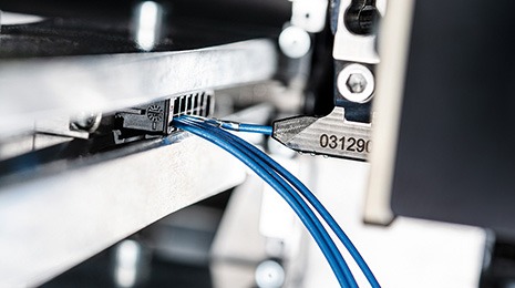 The loading gripper inserts the cable into the housing.